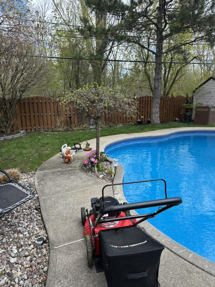 Backyard pool area with lawn equipment during property maintenance