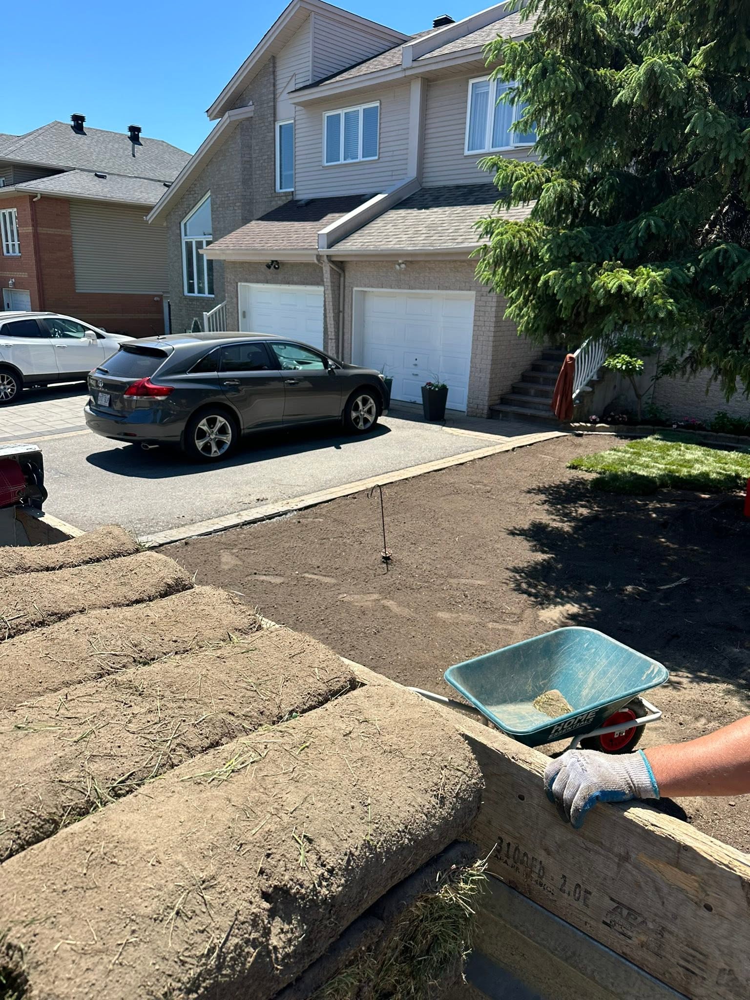 Yard preparation with soil, sod rolls, and wheelbarrow