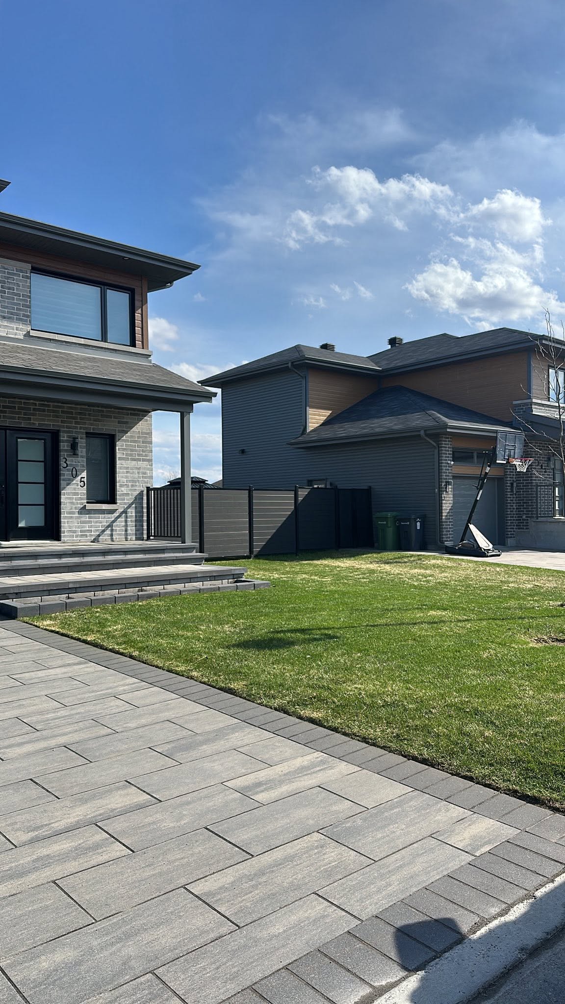 Clean paver driveway and lawn beside a Montreal home